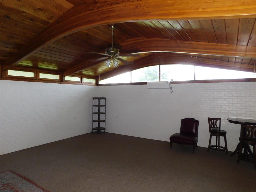 300 South Main Street Springhill, LA 71075 - Photo 14 of 35 a roof deck with table and chairs under an umbrella