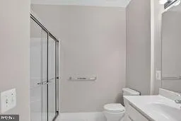 a bathroom with a granite countertop toilet a sink and a mirror