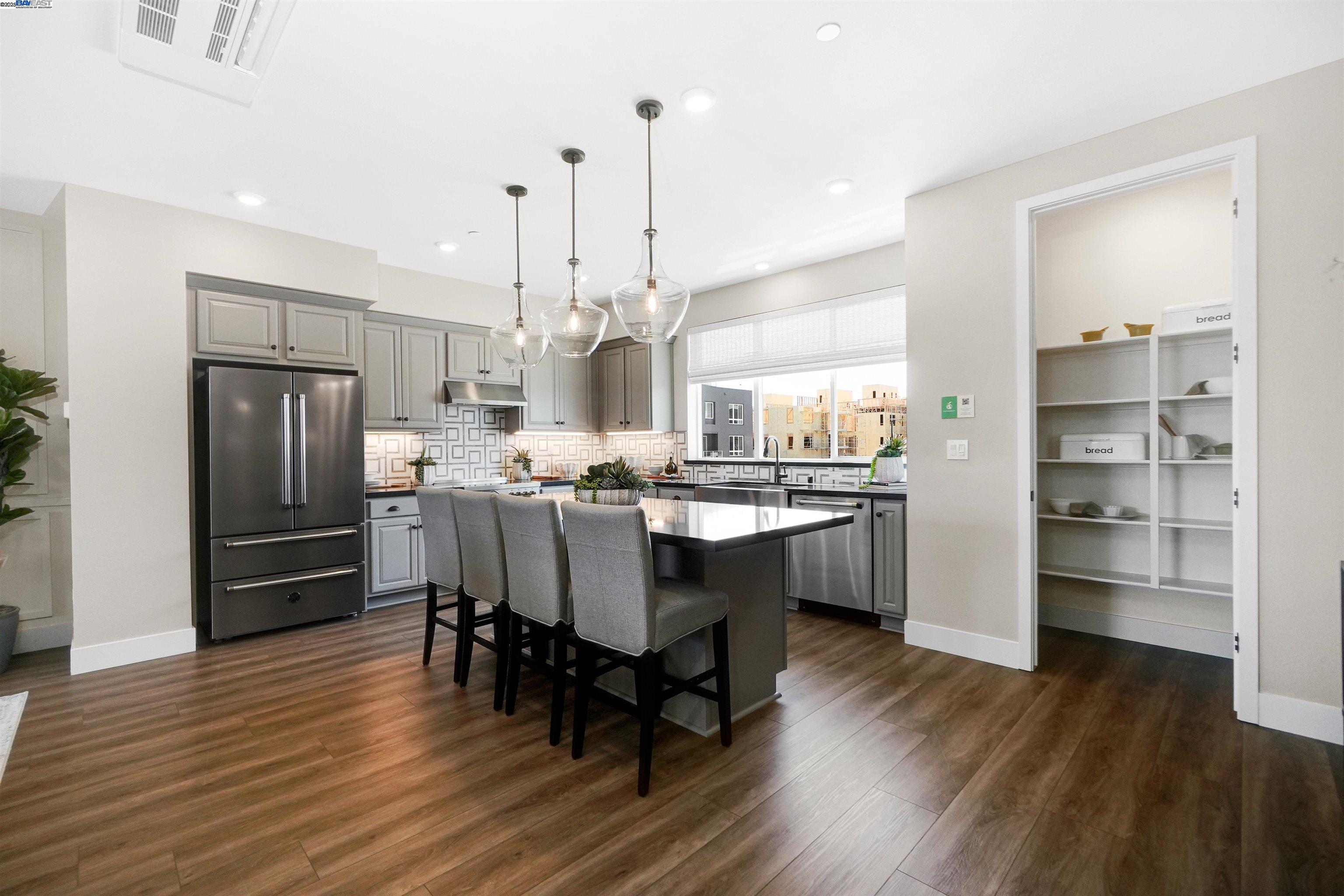 2256 Stanford Street Alameda, CA 94501 - Photo 23 of 60 a kitchen with stainless steel appliances a dining table chairs refrigerator and cabinets