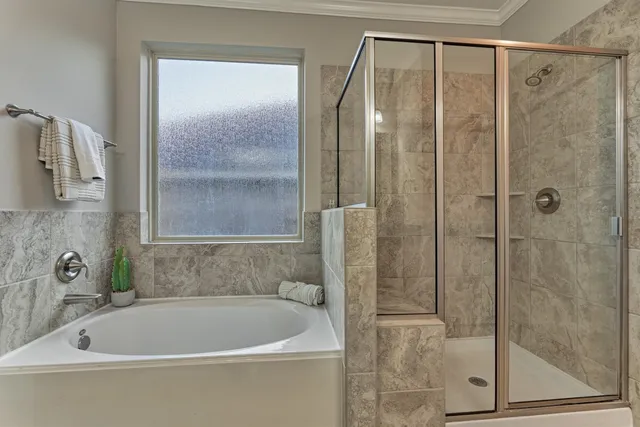 an empty room with chandelier fan and windows