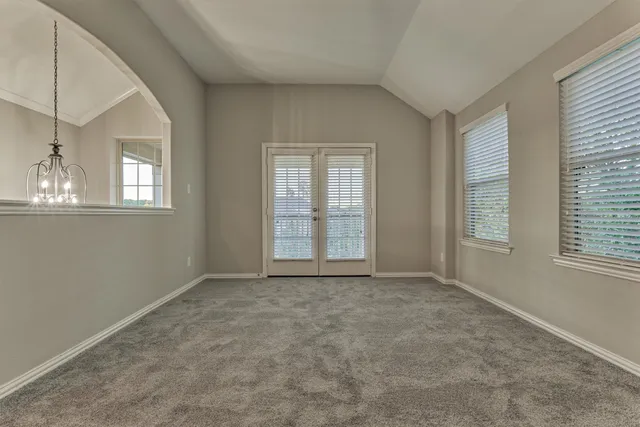 a view of an empty room with a ceiling fan and window