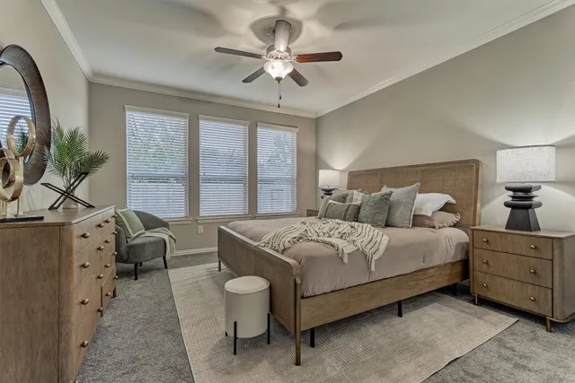 a bedroom with a bed a couch and a large window with the outer view