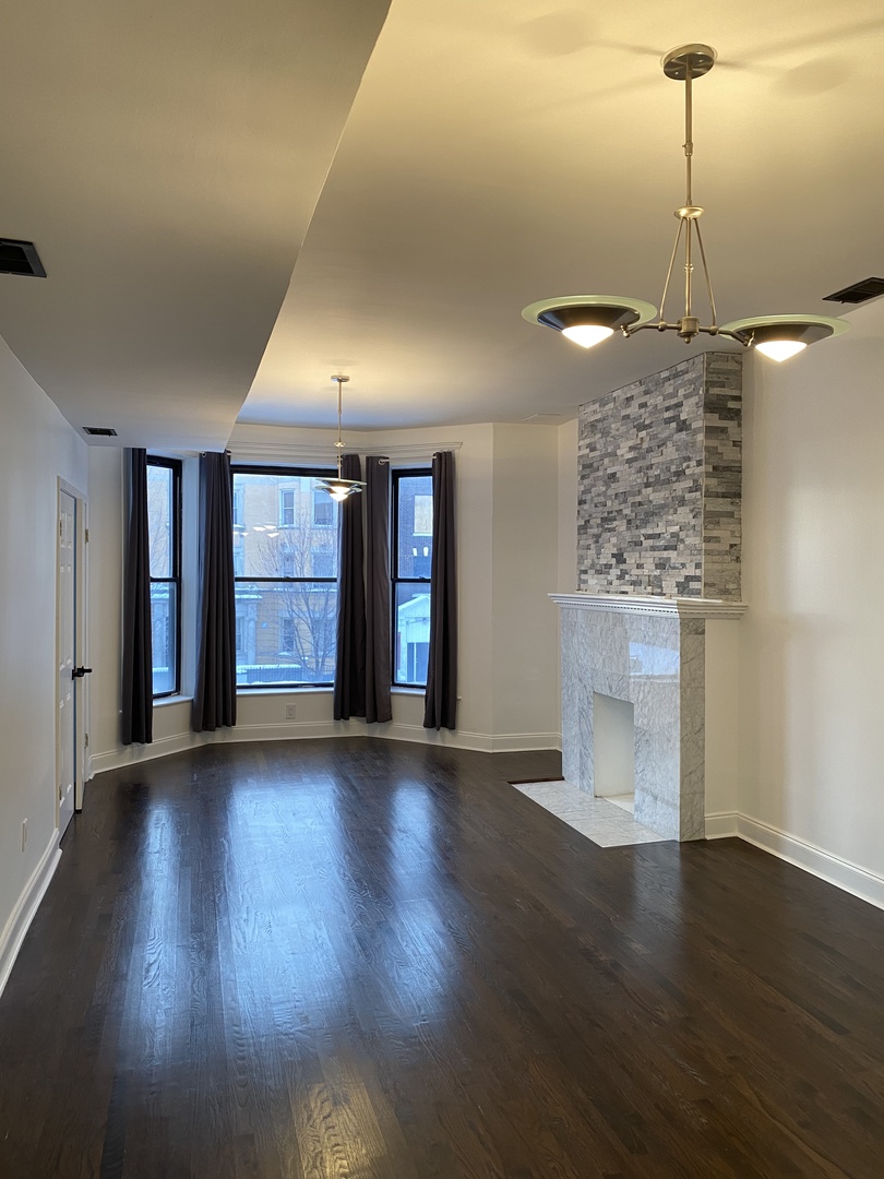 4813 South Prairie Avenue Chicago, IL 60615 - Photo 17 of 27 a view of an empty room with window and wooden floor