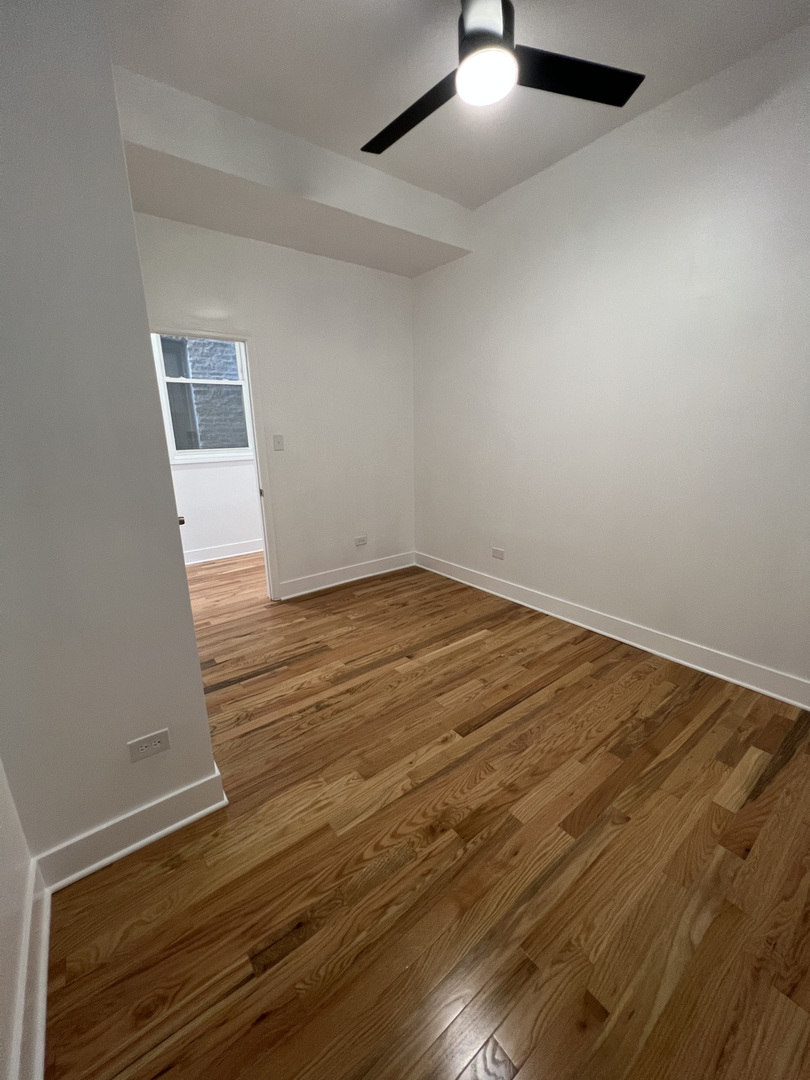 4813 South Prairie Avenue Chicago, IL 60615 - Photo 4 of 27 an empty room with wooden floor and windows