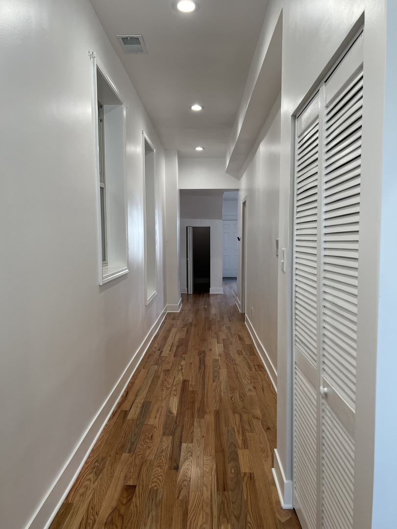 4813 South Prairie Avenue Chicago, IL 60615 - Photo 8 of 27 a view of a hallway with wooden floor and a bathroom