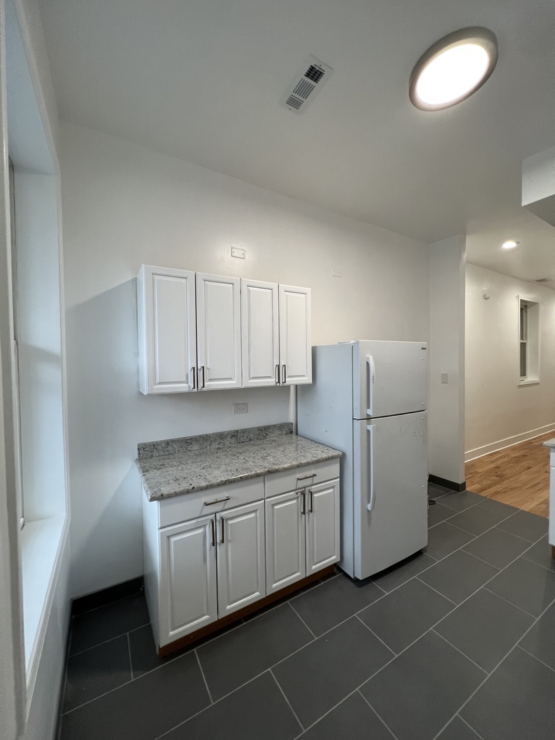 4813 South Prairie Avenue Chicago, IL 60615 - Photo 10 of 27 a kitchen with a sink a refrigerator and cabinets