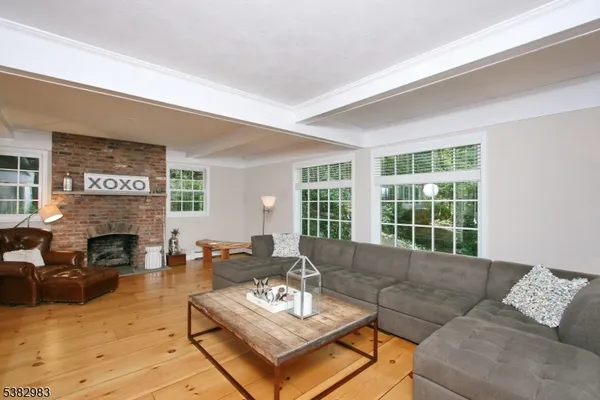 a living room with furniture fireplace and a large window
