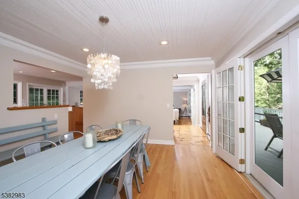 a view of a dining room with furniture a chandelier and wooden floor