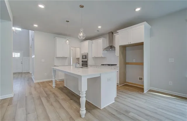 a kitchen with white cabinets and wooden floor