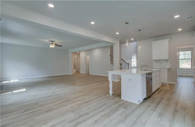 a large white kitchen with wooden floors and white cabinets