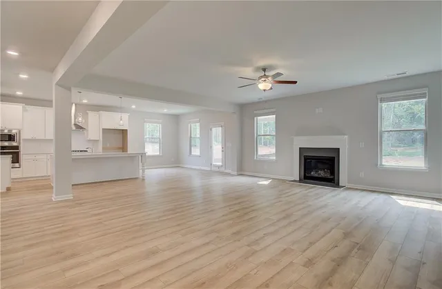 a view of an empty room with a fireplace and a window