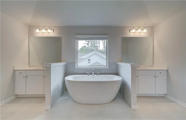 a spacious bathroom with a bathtub and 2 sink