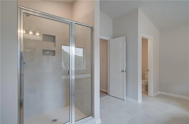 a bathroom with a shower and a glass door