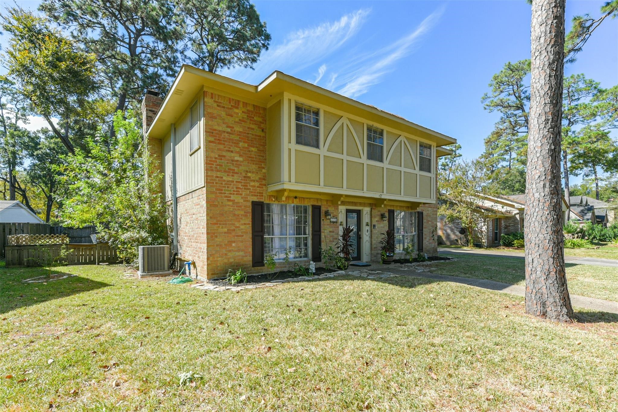 3728 Autumn Lane Baytown, TX 77521 - Photo 2 of 16 This charming two-story home features a classic brick exterior with decorative wood accents. It is surrounded by mature trees and has a well-maintained lawn, offering a welcoming and serene setting.