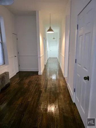 a view of a hallway with wooden floor and stairs