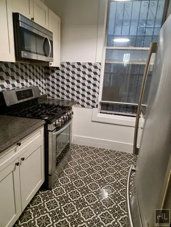 a kitchen with granite countertop a stove and a microwave