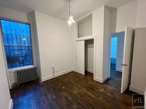 an empty room with wooden floor and a window