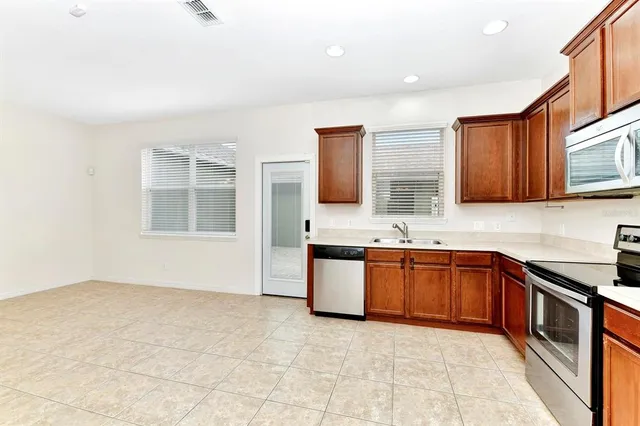 a large kitchen with stainless steel appliances granite countertop a sink stove and cabinets