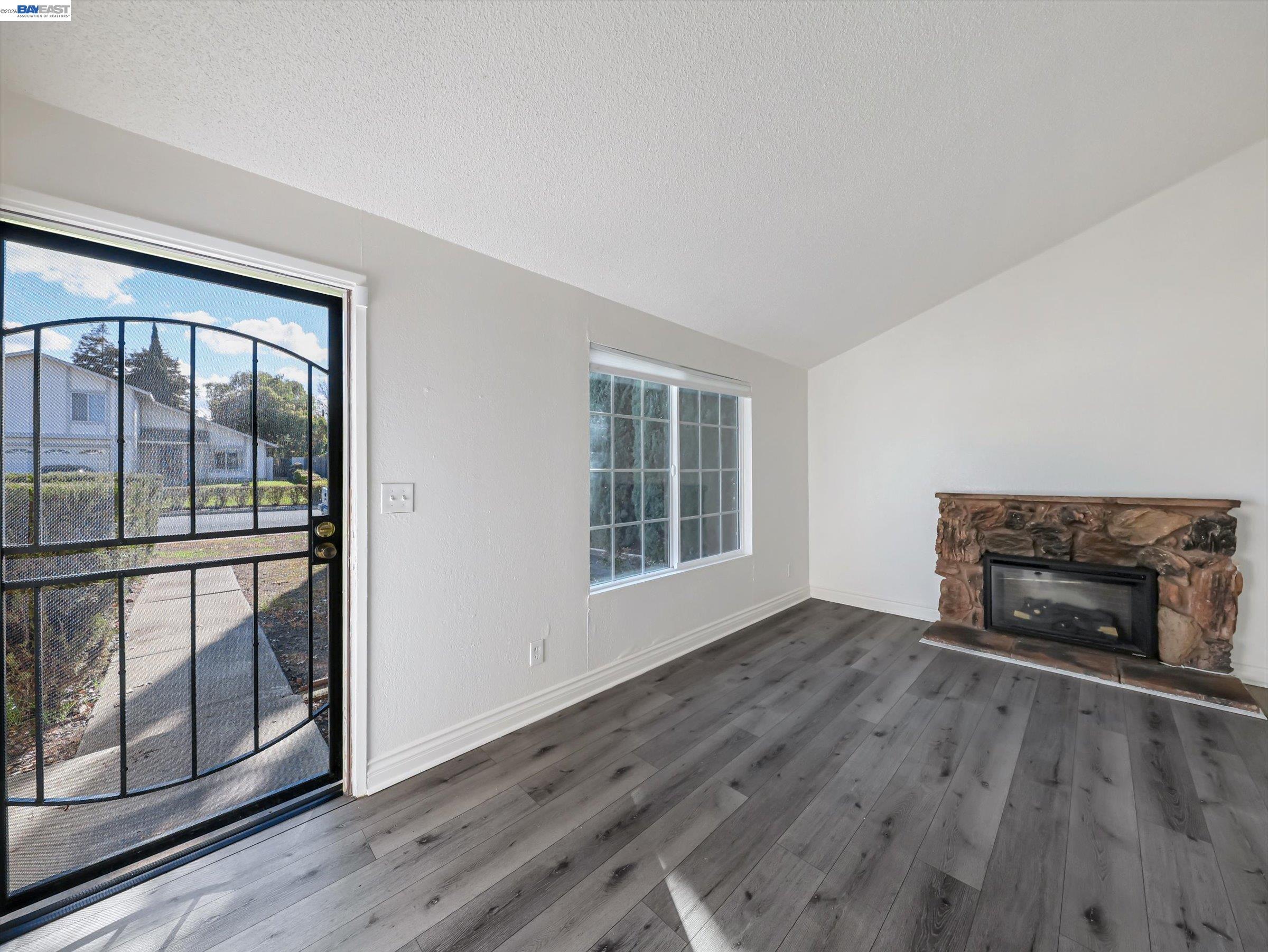 3432 Danielle Place Bay Point, CA 94565 - Photo 5 of 36 an empty room with wooden floor fireplace and windows