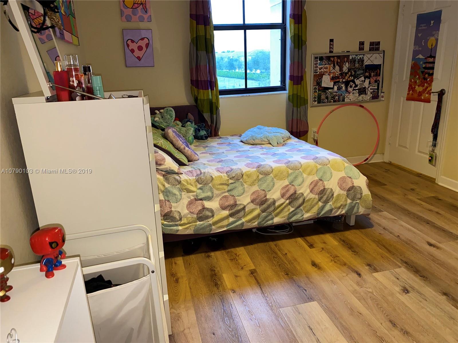 3436 West 90th Street, Unit 3436 Hialeah, FL 33018 - Photo 45 of 56 a bedroom with a bed and dresser with wooden floor