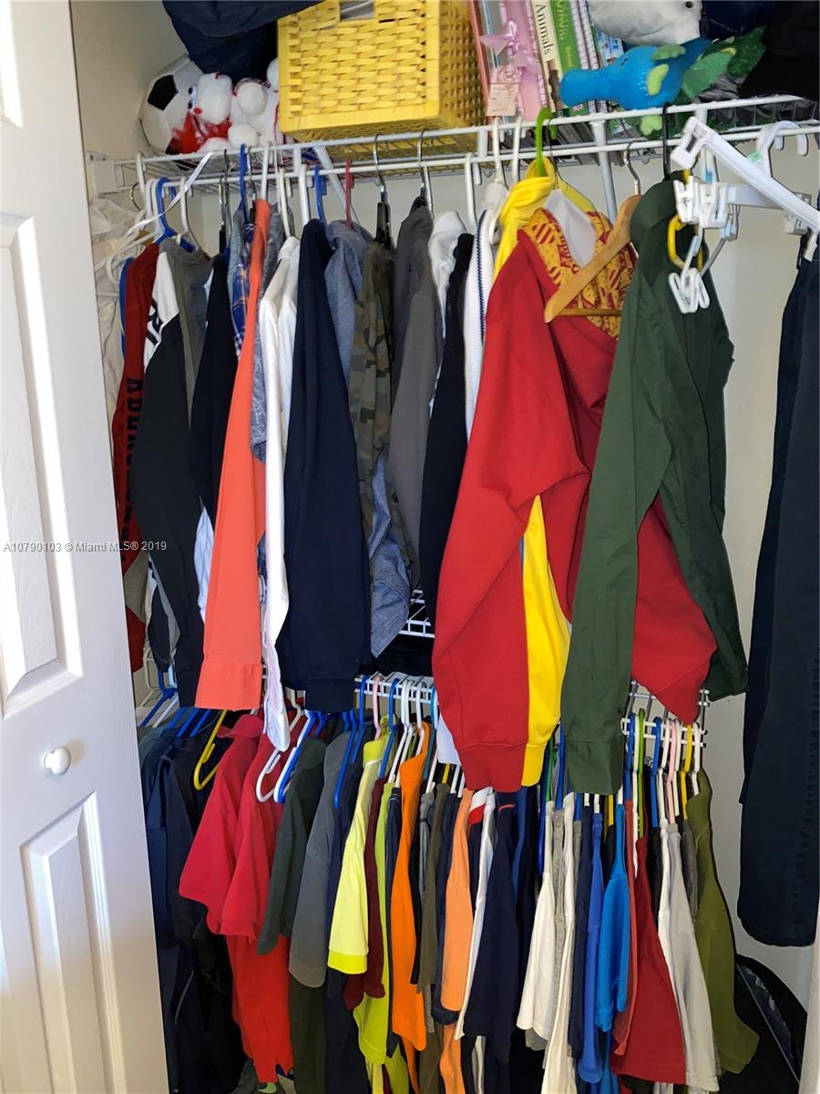 3436 West 90th Street, Unit 3436 Hialeah, FL 33018 - Photo 51 of 56 a view of walk in closet with clothes and shoes