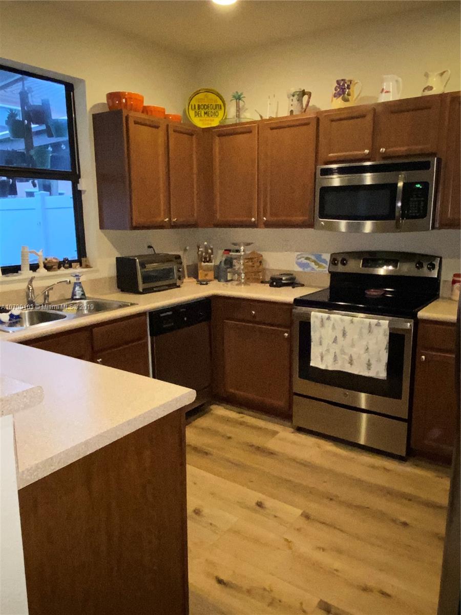 3436 West 90th Street, Unit 3436 Hialeah, FL 33018 - Photo 10 of 56 a kitchen with stainless steel appliances a stove a sink and a microwave