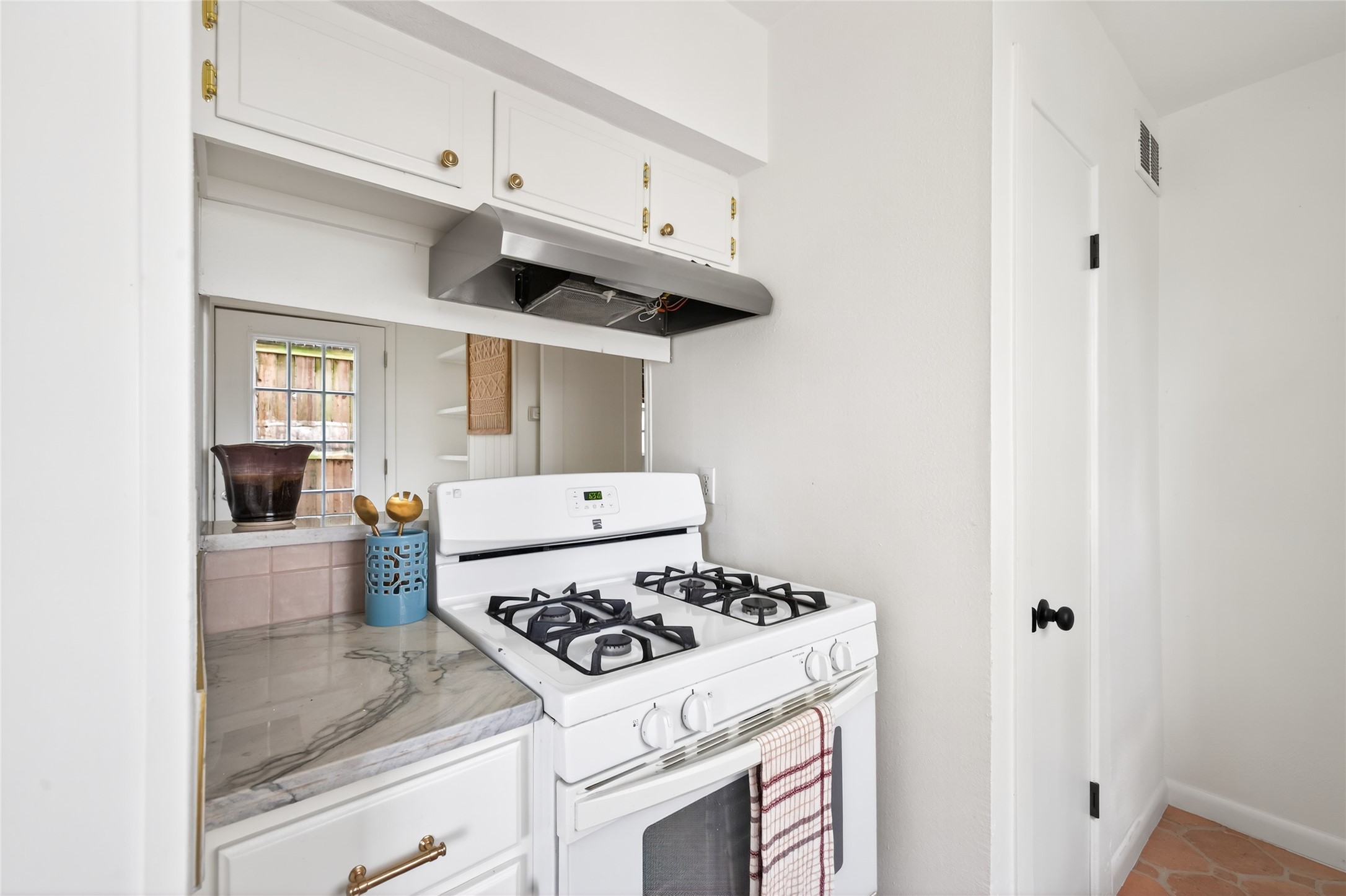 1700 Houston Street, Unit 102 Austin, TX 78756 - Photo 6 of 24 a kitchen with a stove and white cabinets