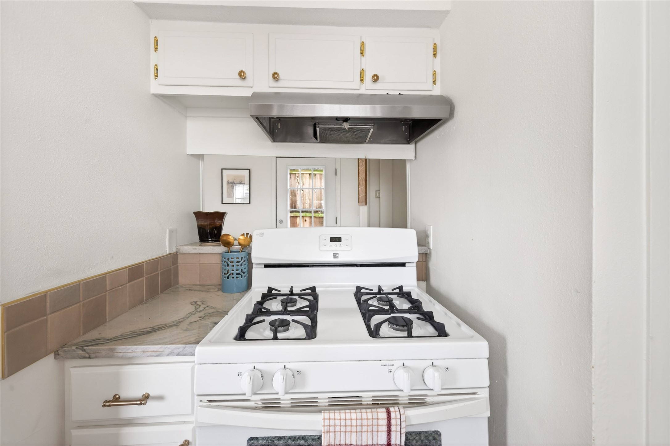 1700 Houston Street, Unit 102 Austin, TX 78756 - Photo 8 of 24 a kitchen with a stove and white cabinets