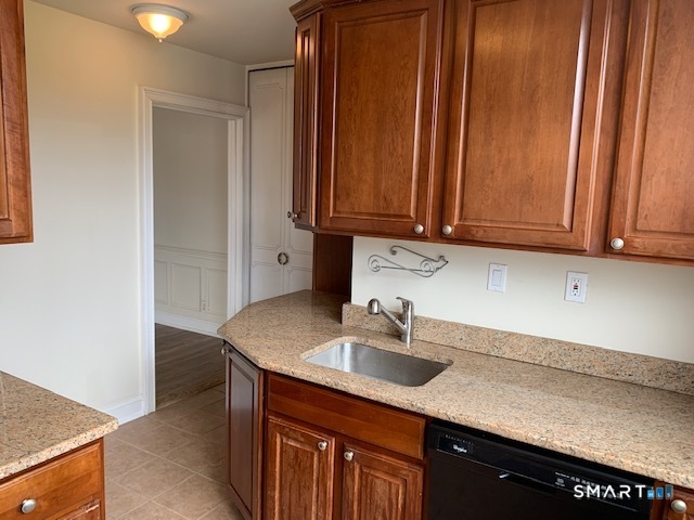 50 Glenbrook Road, Unit 5G Stamford, CT 06902 - Photo 23 of 40 a kitchen with stainless steel appliances granite countertop a sink dishwasher and cabinets with wooden floor