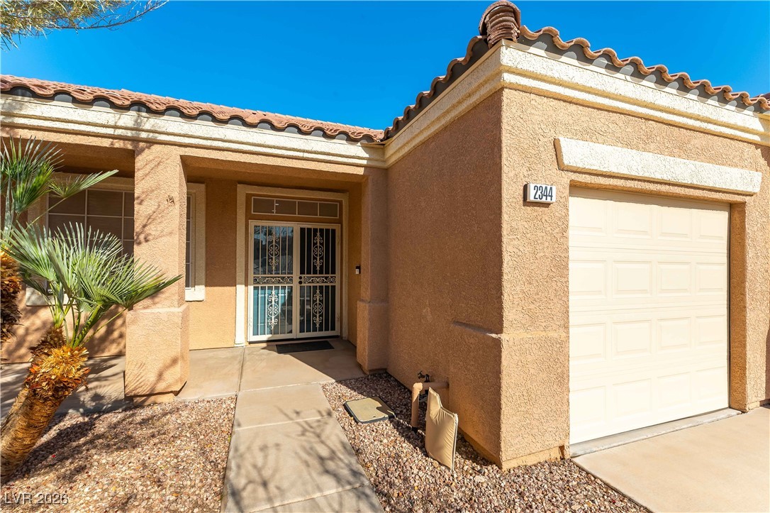 2344 Teton Ranch Avenue Henderson, NV 89052 - Photo 11 of 32 View of front of house with stucco siding, an attached garage, concrete driveway, and a tiled roof