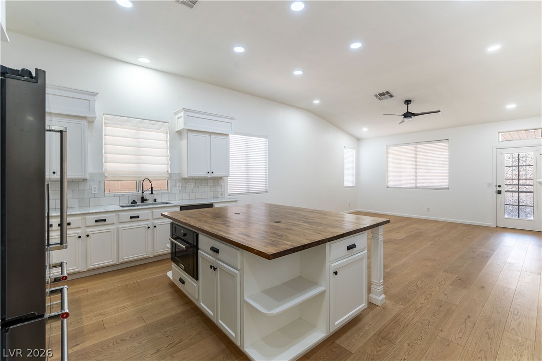 2344 Teton Ranch Avenue Henderson, NV 89052 - Photo 2 of 32 Kitchen featuring white cabinetry, freestanding refrigerator, butcher block counters, light wood finished floors, and a kitchen island