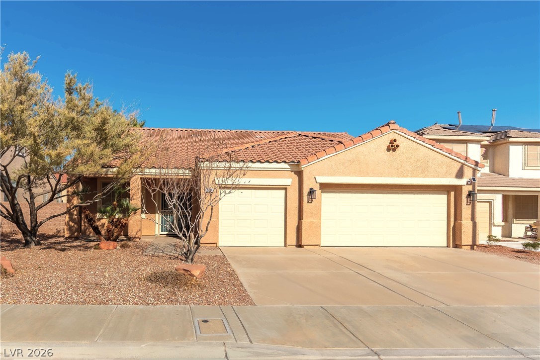 2344 Teton Ranch Avenue Henderson, NV 89052 - Photo 10 of 32 View of front facade featuring stucco siding, an attached garage, driveway, and a tile roof