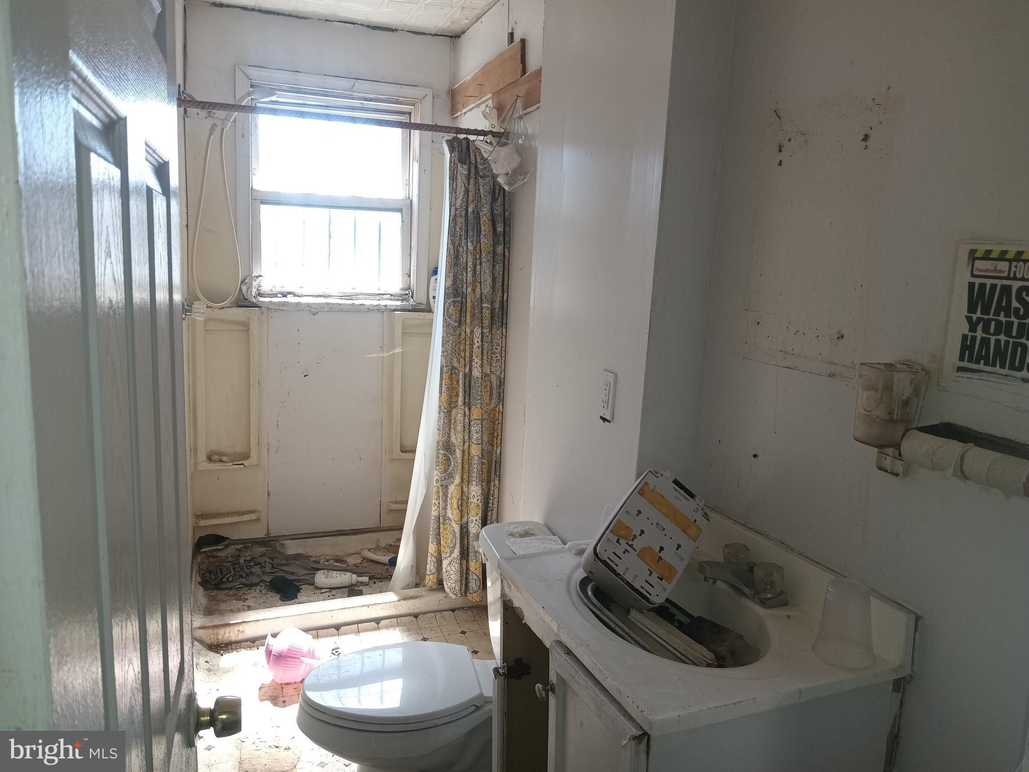 2535 East Monument Street Baltimore, MD 21205 - Photo 6 of 13 a bathroom with a sink toilet and shower