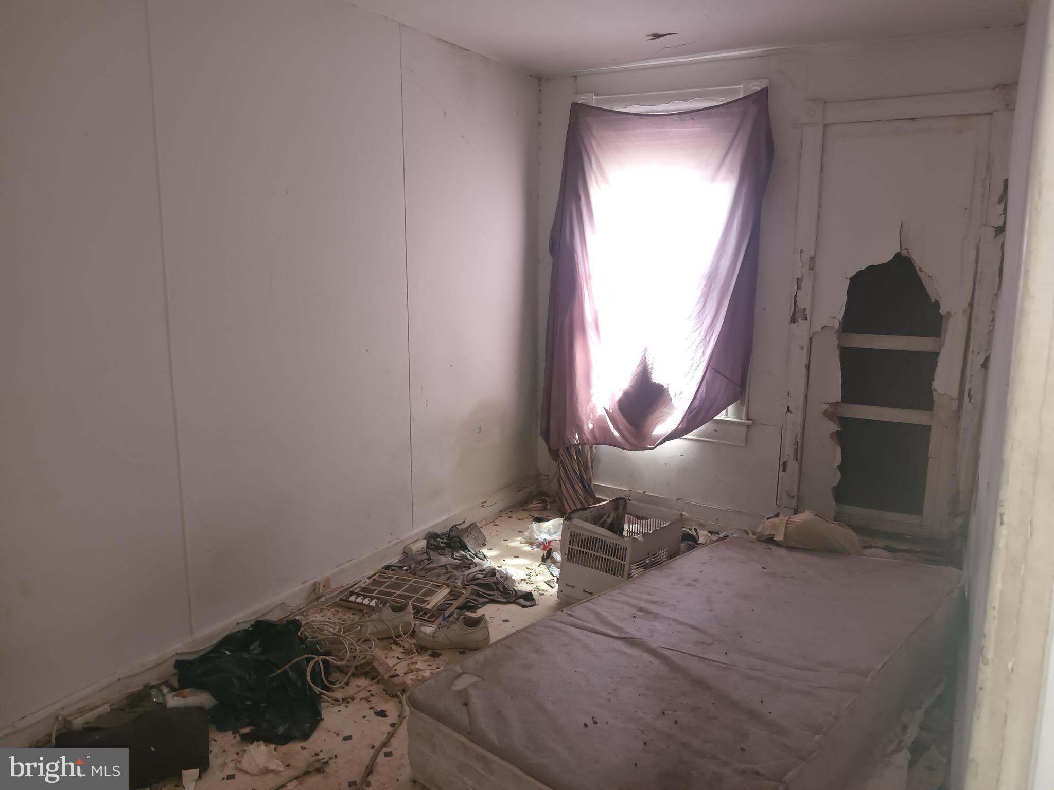 2535 East Monument Street Baltimore, MD 21205 - Photo 8 of 13 a room with exposed radiator and a wooden floor