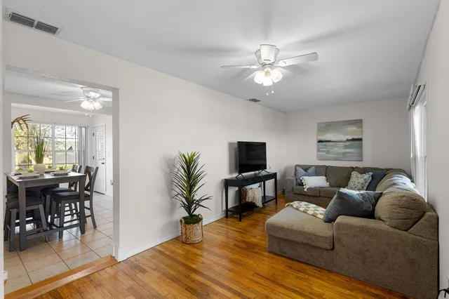a living room with furniture a chandelier and a flat screen tv