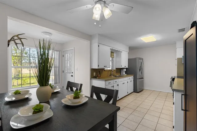 a kitchen with stainless steel appliances kitchen island granite countertop wooden floor a refrigerator and a sink