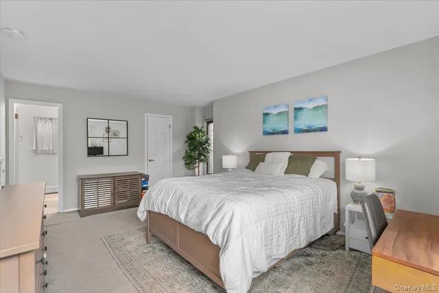 a bedroom with a large bed a couch and painting on the wall