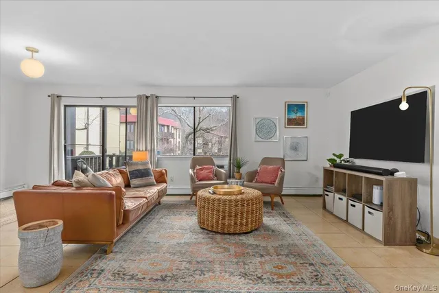 a living room with furniture a flat screen tv and large window