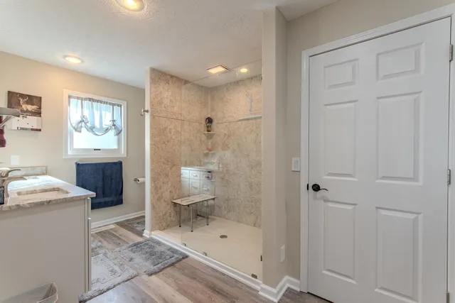 a bathroom with a granite countertop sink a toilet and shower