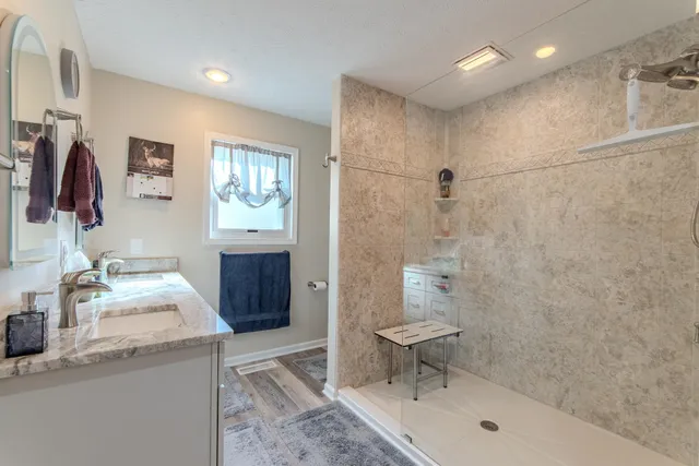 a bathroom with a sink a toilet and shower