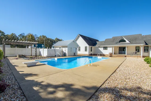 a view of house with swimming pool and lake view