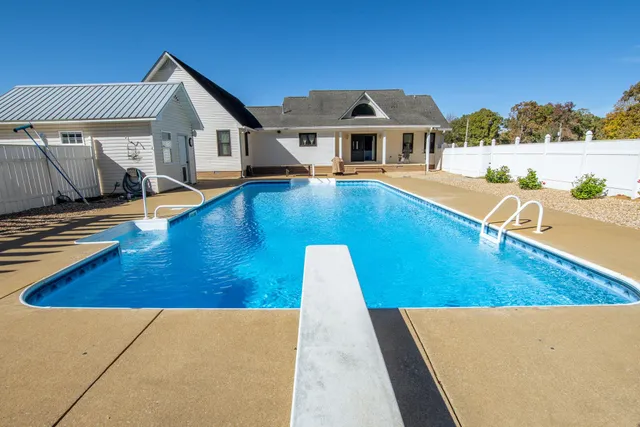 a view of a house with pool and chairs