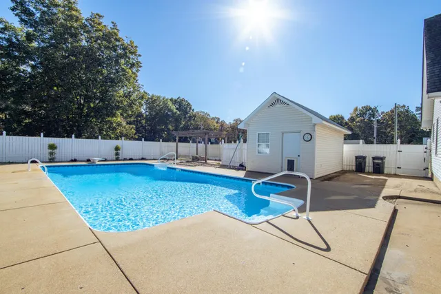 a view of backyard with swimming pool and seating space