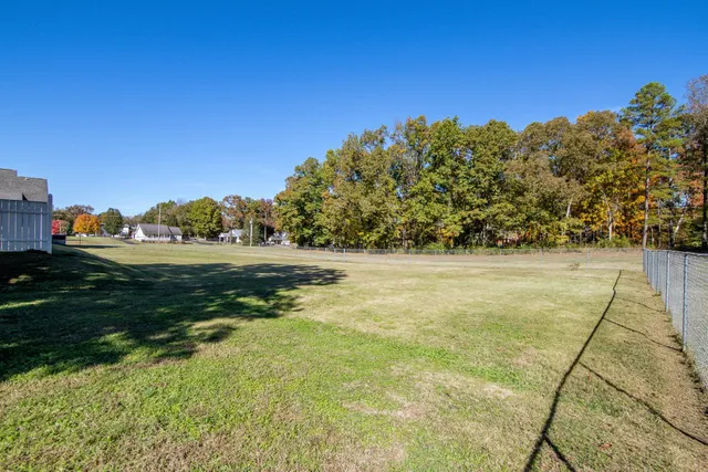a view of yard with swimming pool and trees
