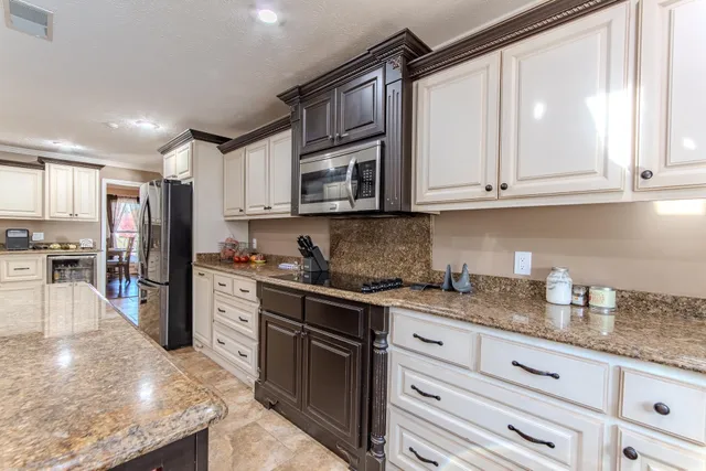 a kitchen with granite countertop cabinets stainless steel appliances and a counter space