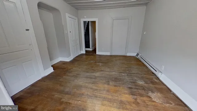 a view of empty room with wooden floor