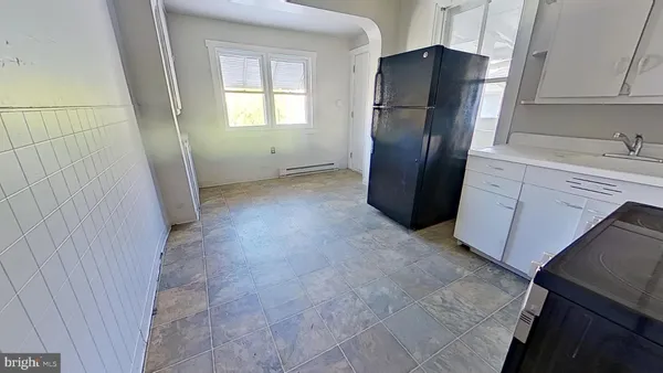 a kitchen with granite countertop a refrigerator and a sink