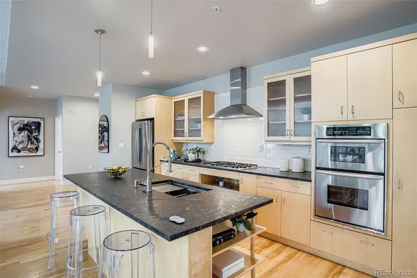 a kitchen with stainless steel appliances granite countertop a stove a sink and a microwave