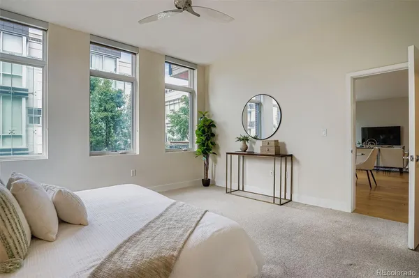 a bedroom with a bed a mirror and a large window