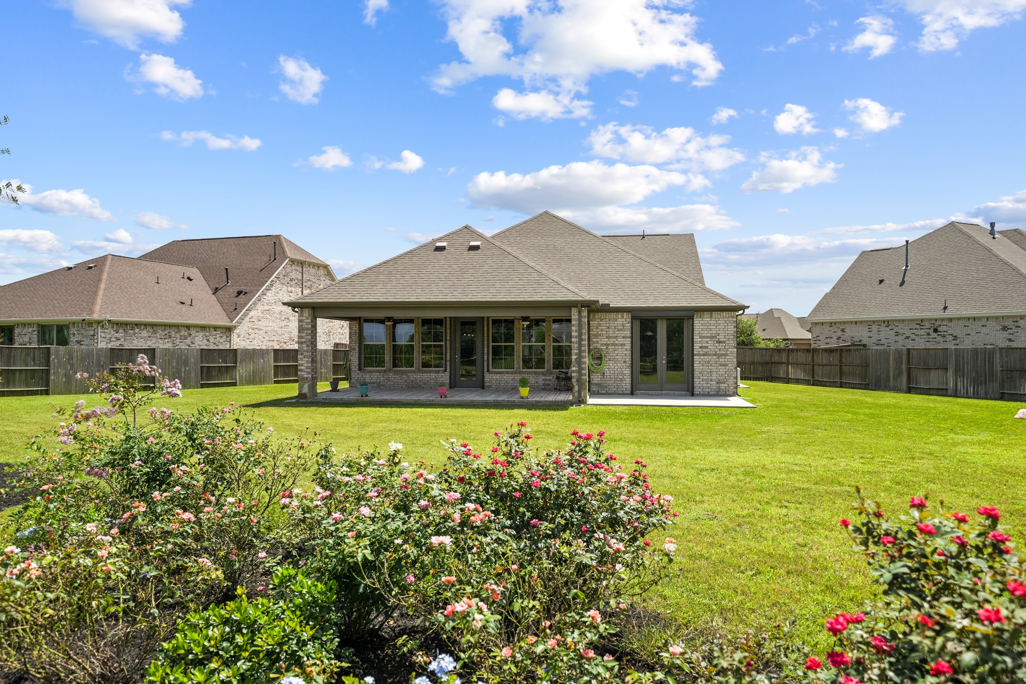 5739 Bobwhite Trail Manvel, TX 77578 - Photo 24 of 29 The covered patio overlooks a beautifully maintained backyard, creating a seamless connection between indoor and outdoor living. Thoughtfully landscaped gardens add charm and color throughout the space.